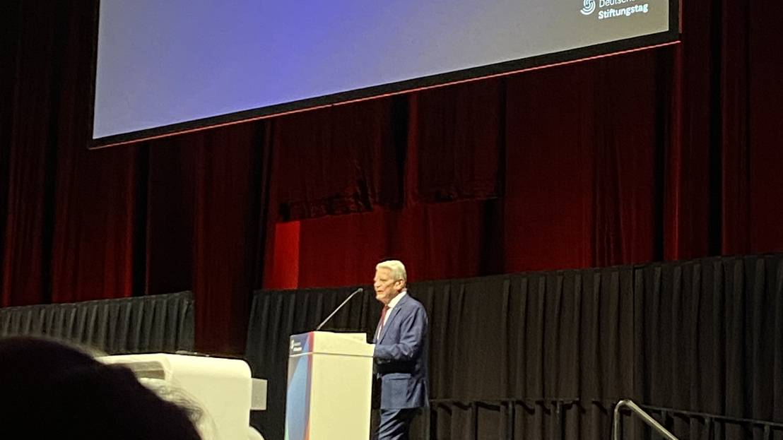 Herr Gauck steht auf der Bühne an einem Rednerpult des Deutschen Stiftungstags 2025, hinter ihm eine Projektion von "Mutig machen"