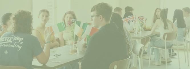 An mehreren Tischen sitzen Gruppen von Schüler:innen mit Flaggen auf dem Tisch, Foto mit grünem Overlay