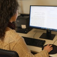 Foto von Eileen am Computer bei der Arbeit an einem Dokument.